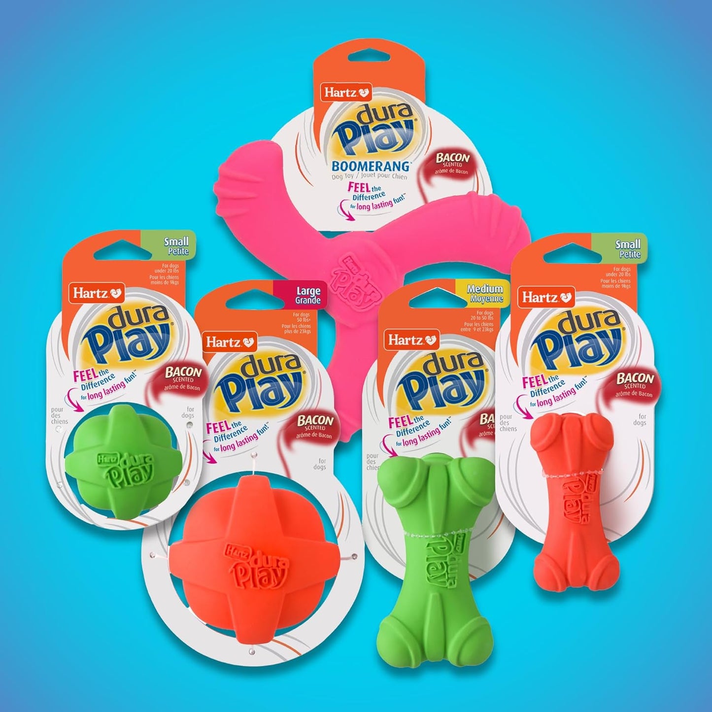 A collection of three different colored Hartz pet play bones resting on grass.