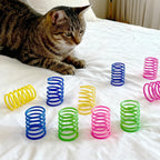 Multi color spiral coil pet toys scattered around a living room setting