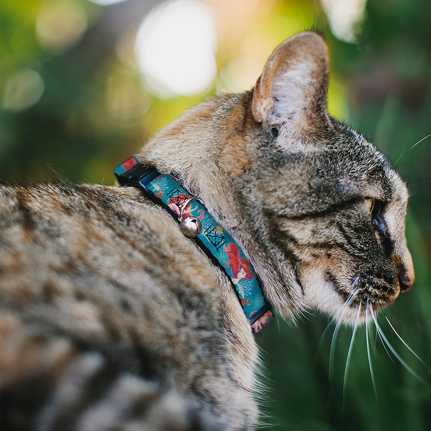 Adjustable green Disney cat collar showing the breakaway plastic safety clip mechanism close up