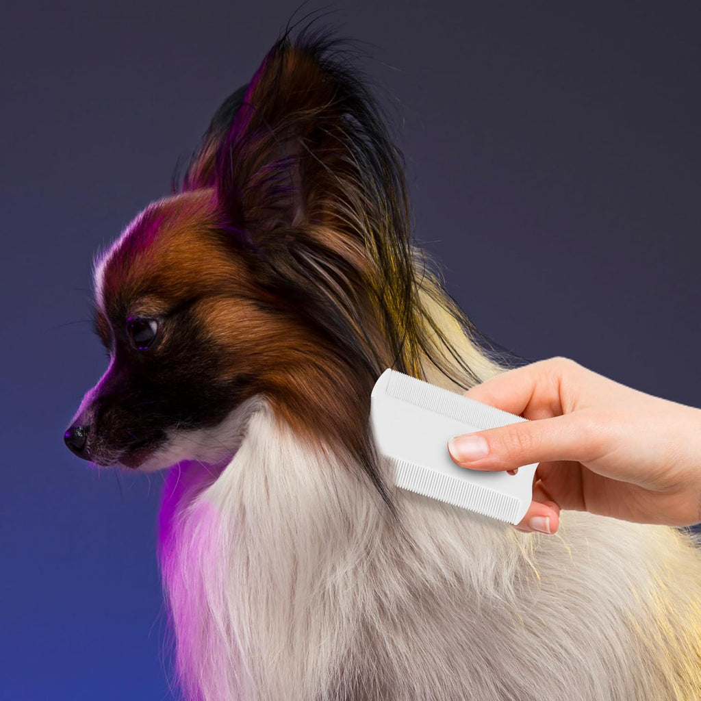 White plastic flea comb removing debris from pet fur