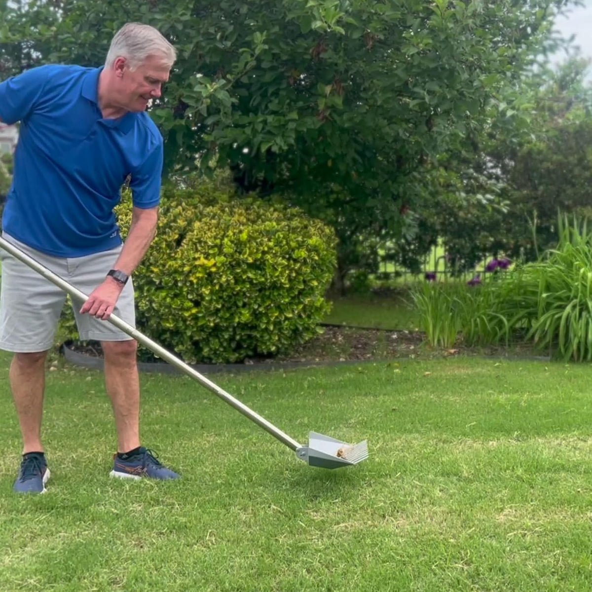 CKLT large dog waste removal shovel being rinsed with a garden hose to show the easy maintenance and non stick metal surface.