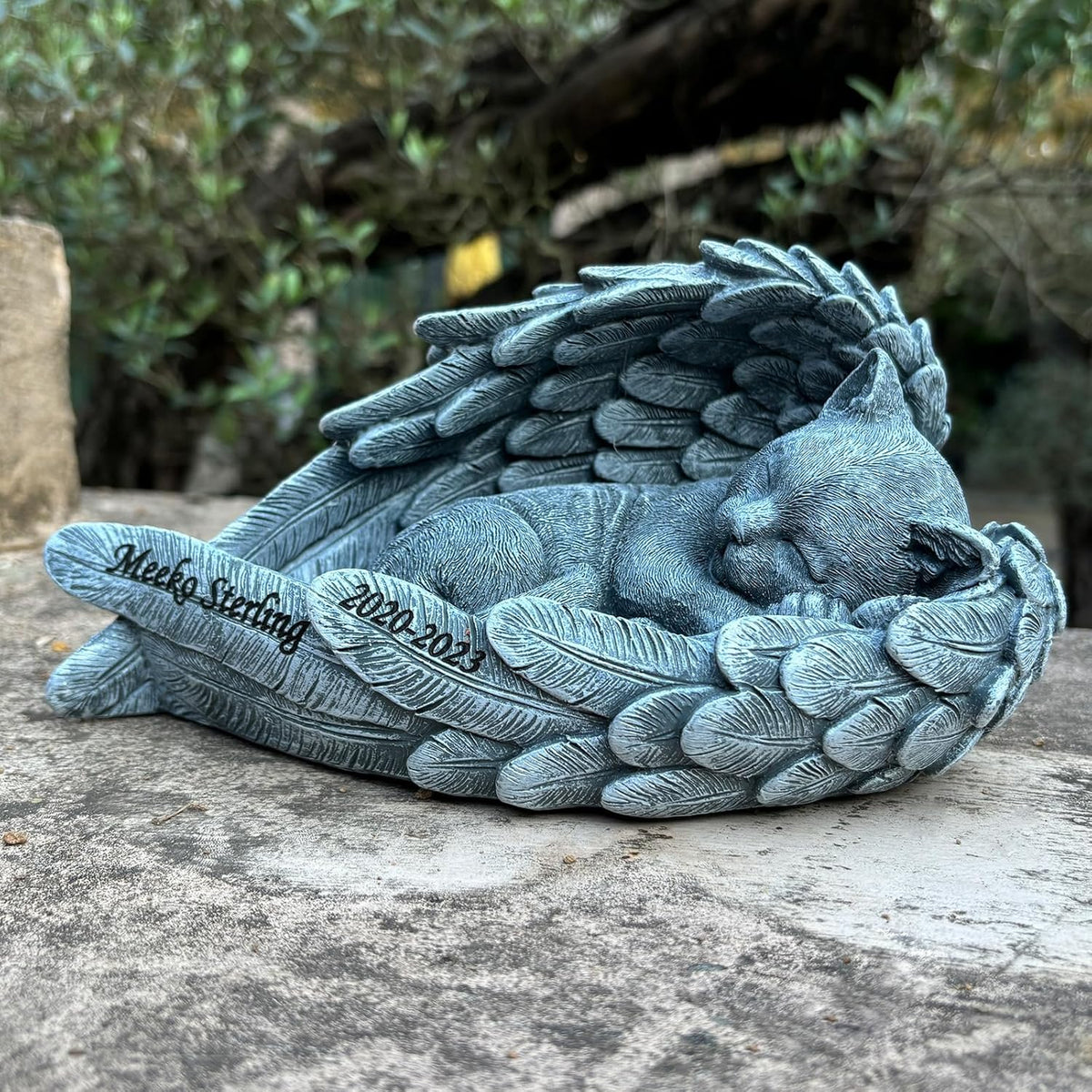 Youruitom angel cat statue grave marker placed outdoors in a garden setting