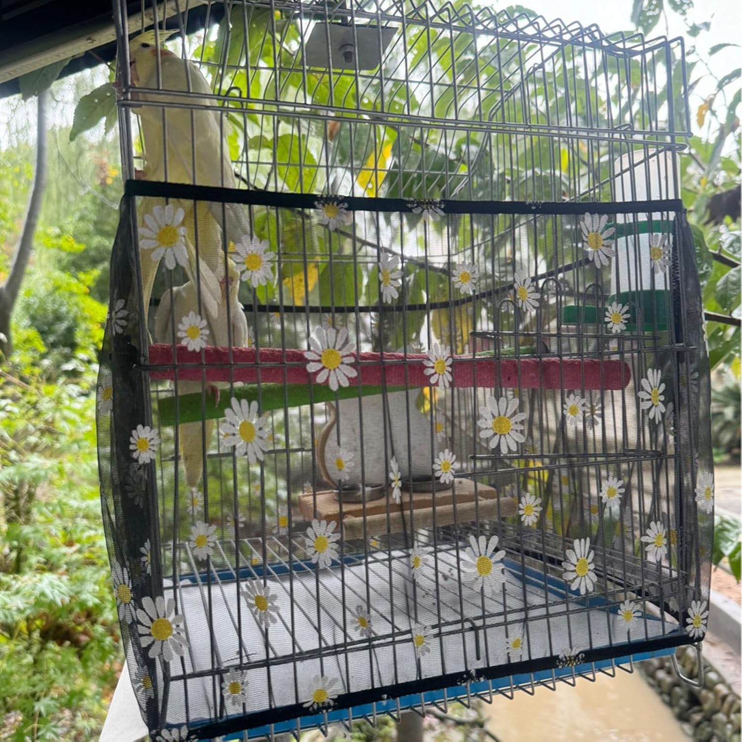 Black mesh bird seed guard net catching scattered birdseed around cage base.