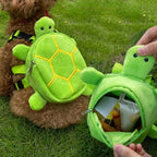 Small dog wearing green plush turtle backpack harness for walking