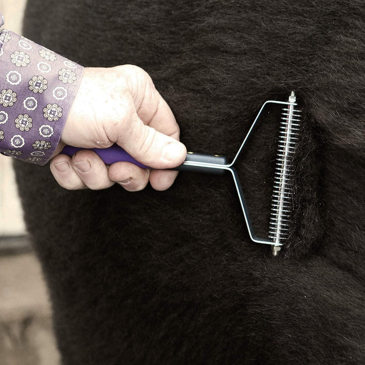 Close up of the durable steel Y frame and non slip rubber grip handle of Weaver grooming tool