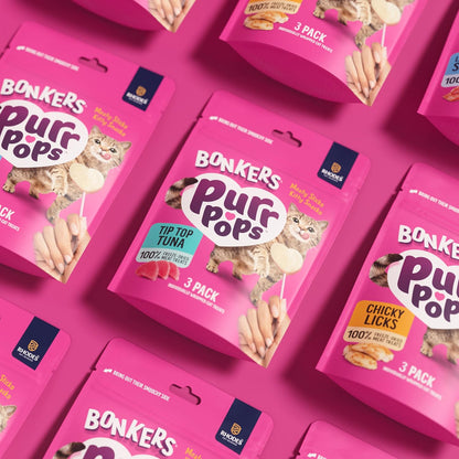 Tuna flavor cat candy lollipop treat being crumbled over dry kibble as a food topper.
