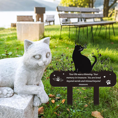 Weatherproof cat memorial stake inserted into backyard lawn soil