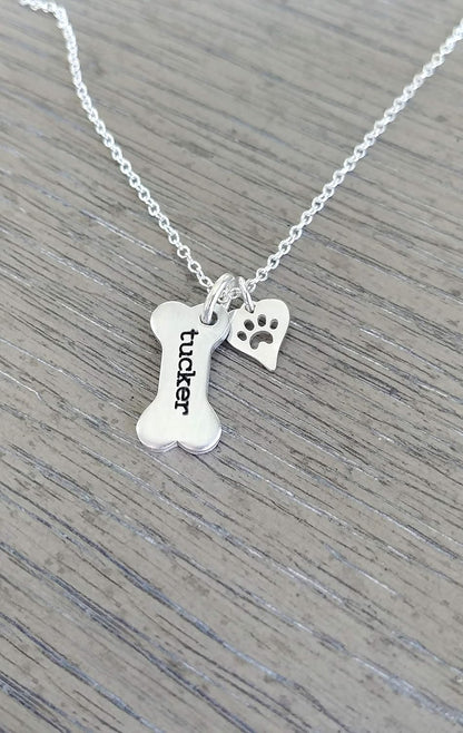 Detailed view of the 12 character engraved dog bone charm on silver chain