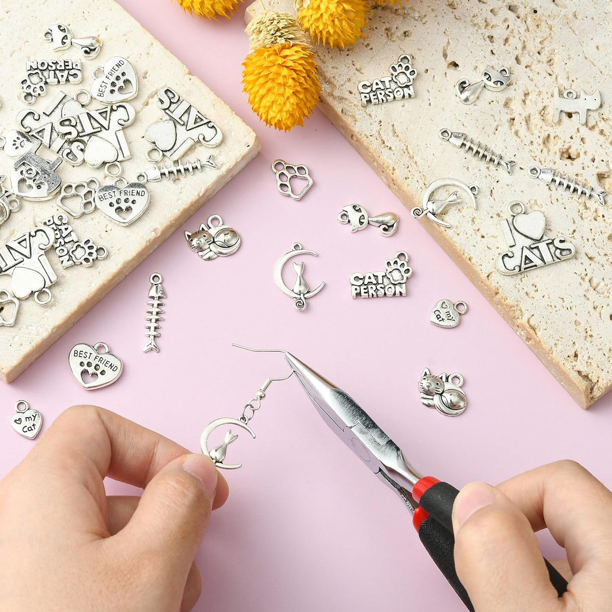 Close-up view of heart and paw print cat charms for DIY bracelets