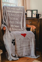 Sixty by fifty inches gray pet memorial throw blanket draped over a living room armchair.