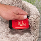 Ergonomic handle design of the red Lilly Brush fur remover held in hand.
