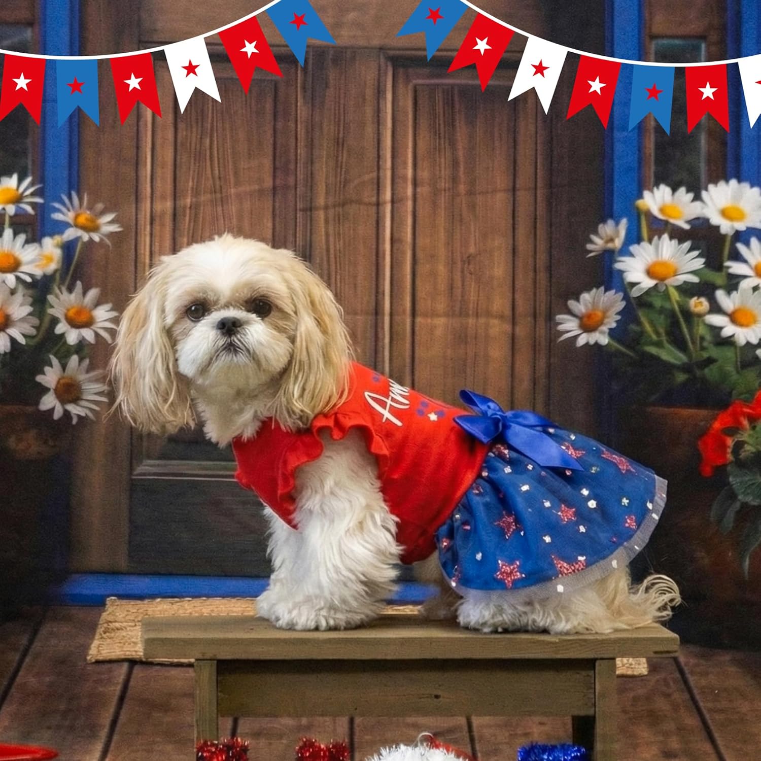 Side angle of small puppy wearing blue star-spangled tulle pet dress