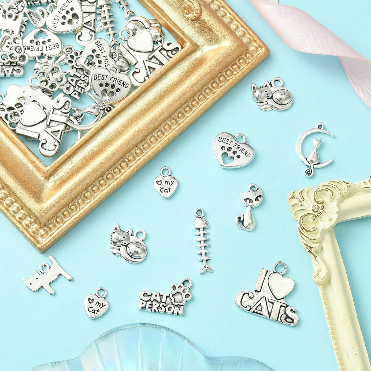Detailed display of antique silver alloy charms including cat-on-moon designs