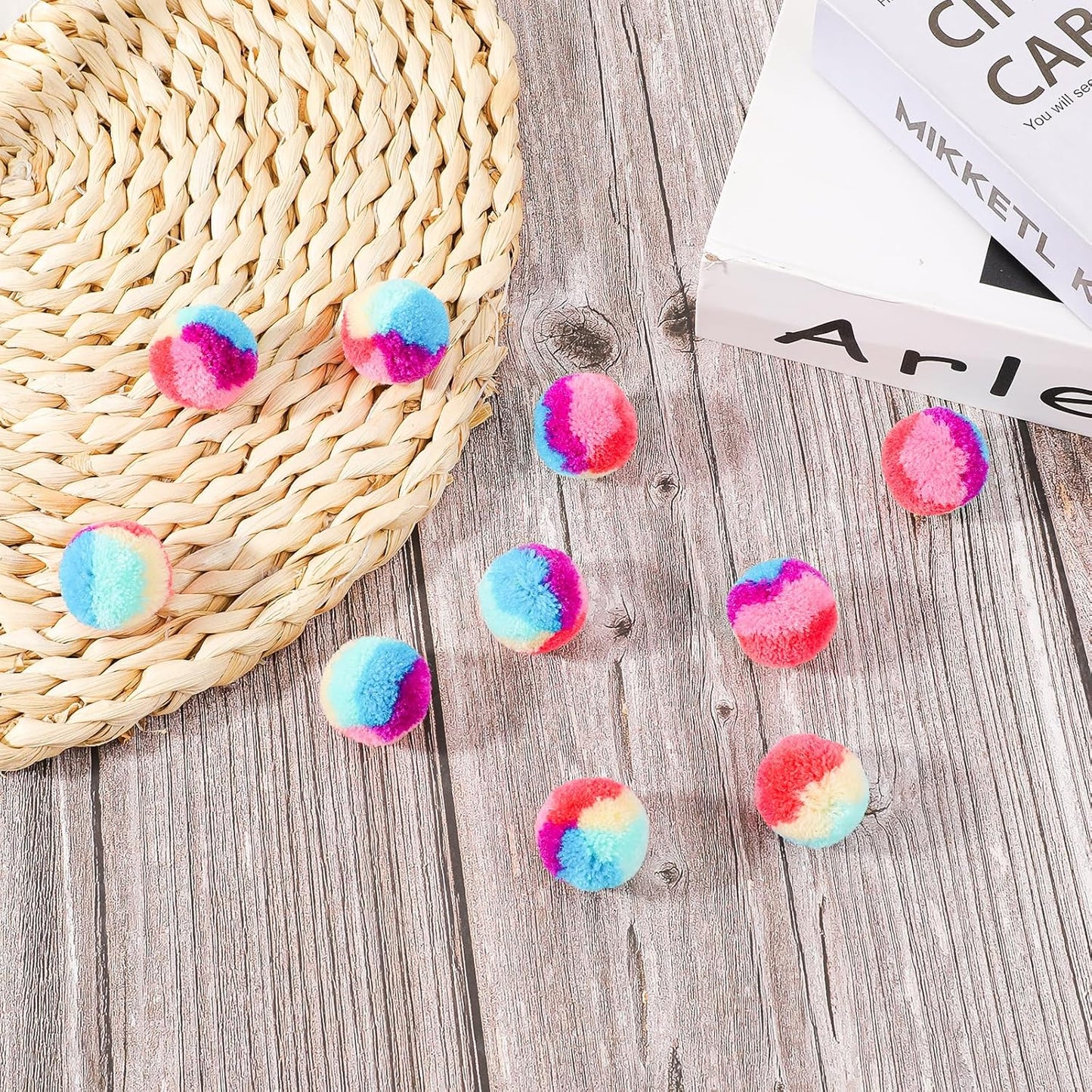 Top down view of 30 piece colorful cat pom pom ball collection