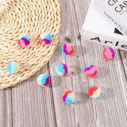 Top down view of 30 piece colorful cat pom pom ball collection