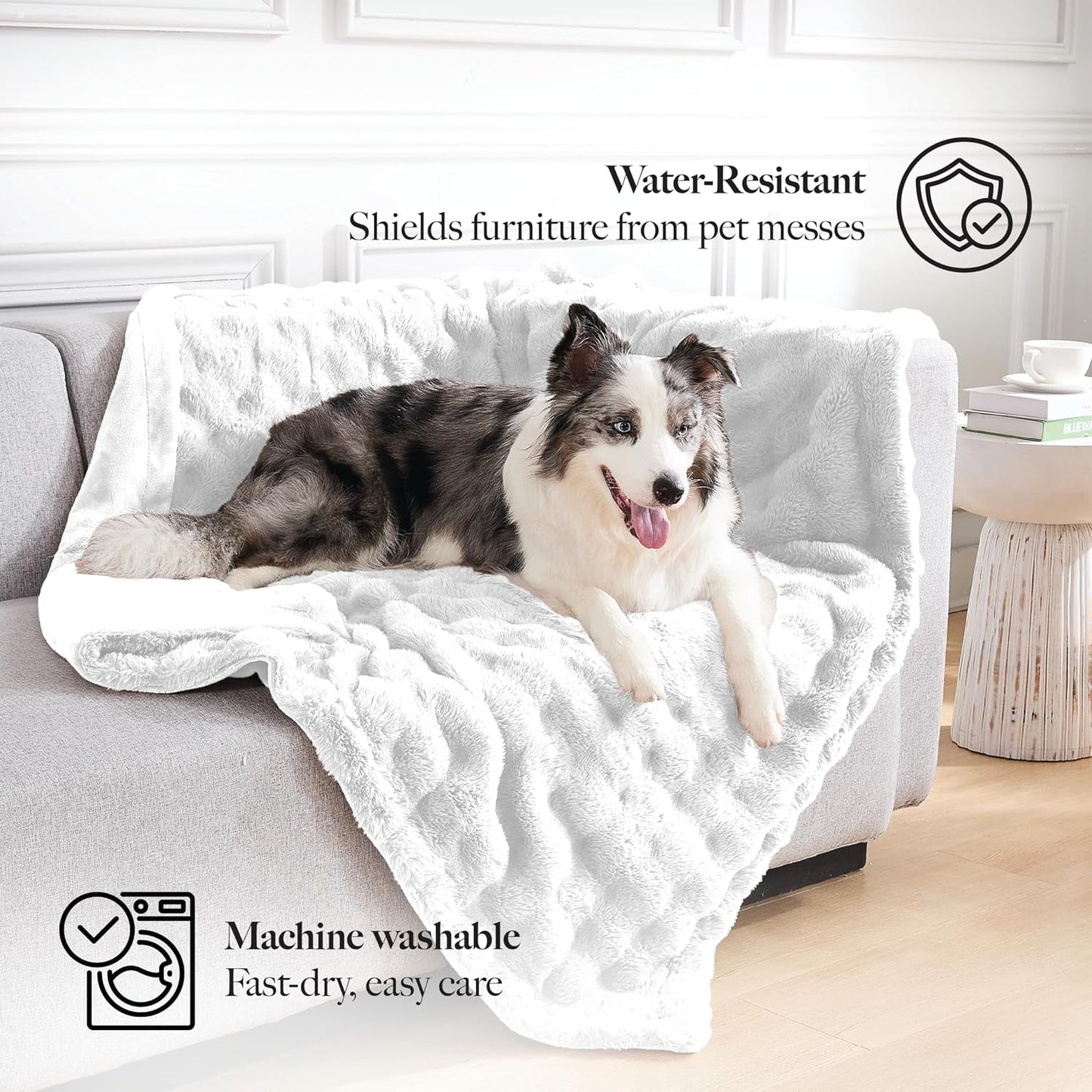 White faux fur pet blanket neatly folded on top of a bedroom mattress.