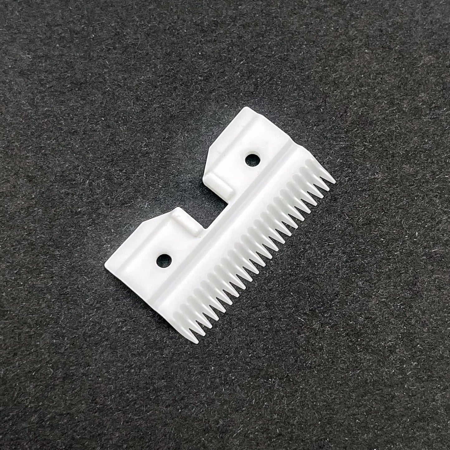 White ceramic pet clipper replacement blade parts on a clean backdrop