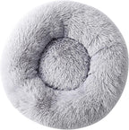 Top down view of small dog resting in circular donut bed