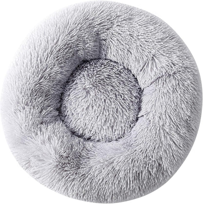 Top down view of small dog resting in circular donut bed