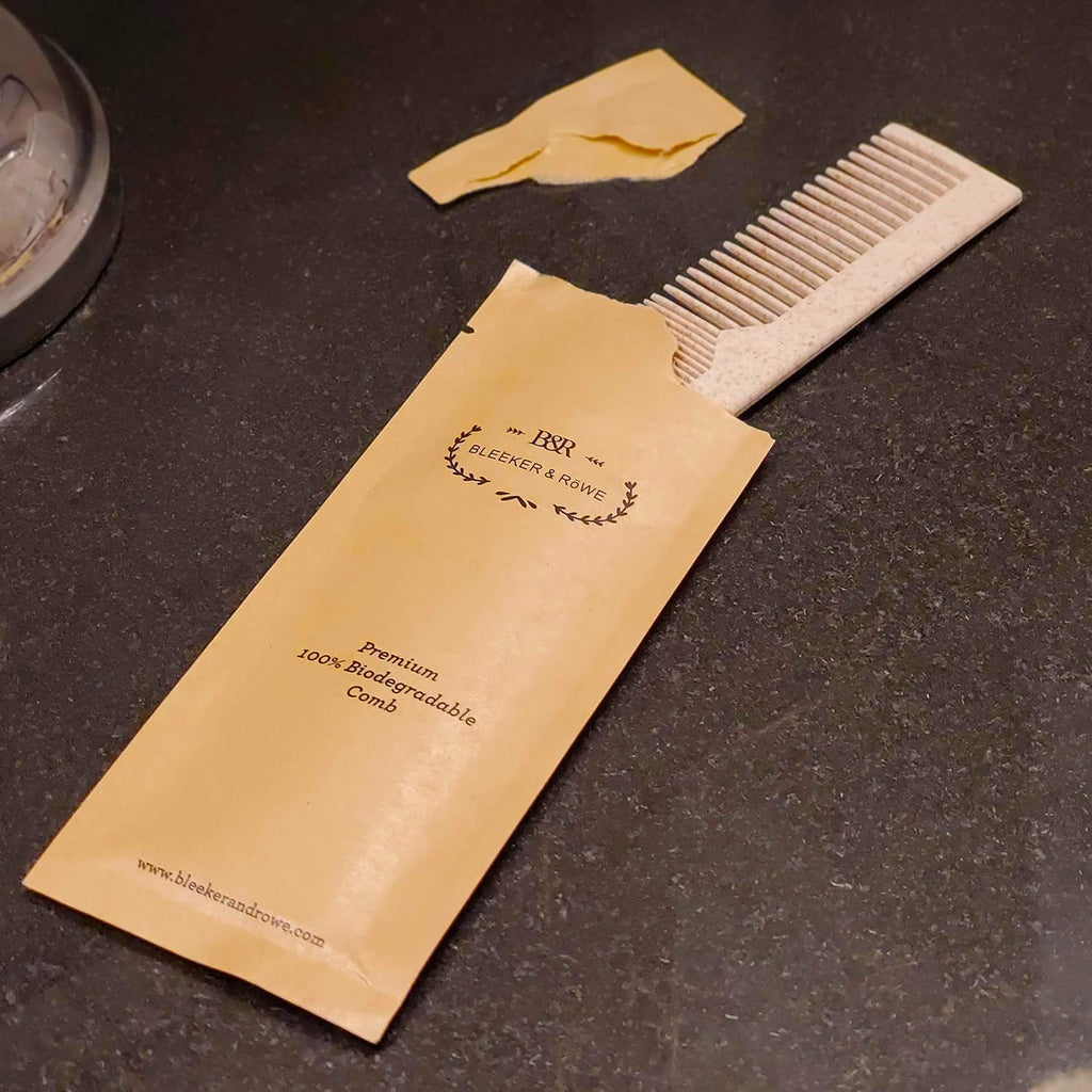 Biodegradable pet dog grooming pocket comb next to eco friendly packaging