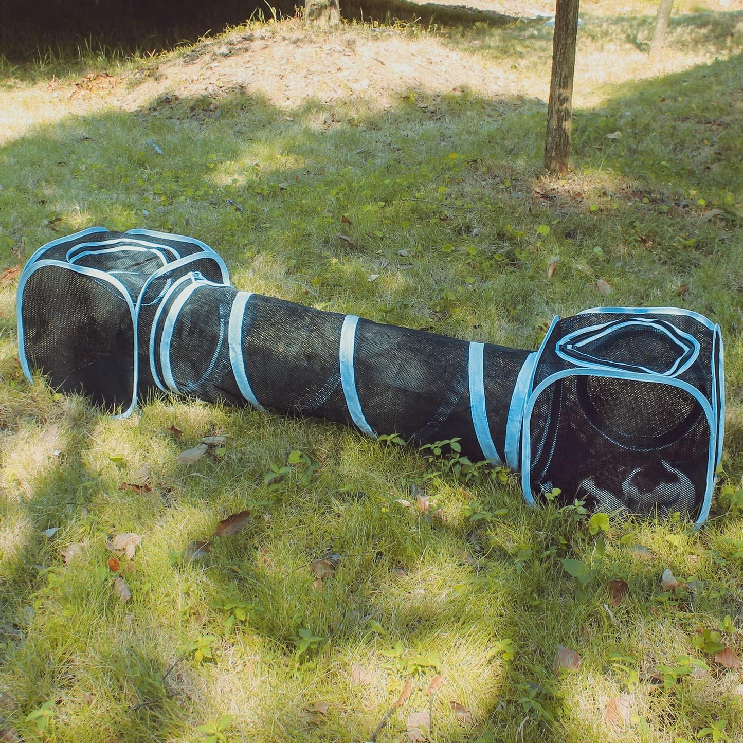 Claw resistant black mesh cat tent secured on lawn with pegs