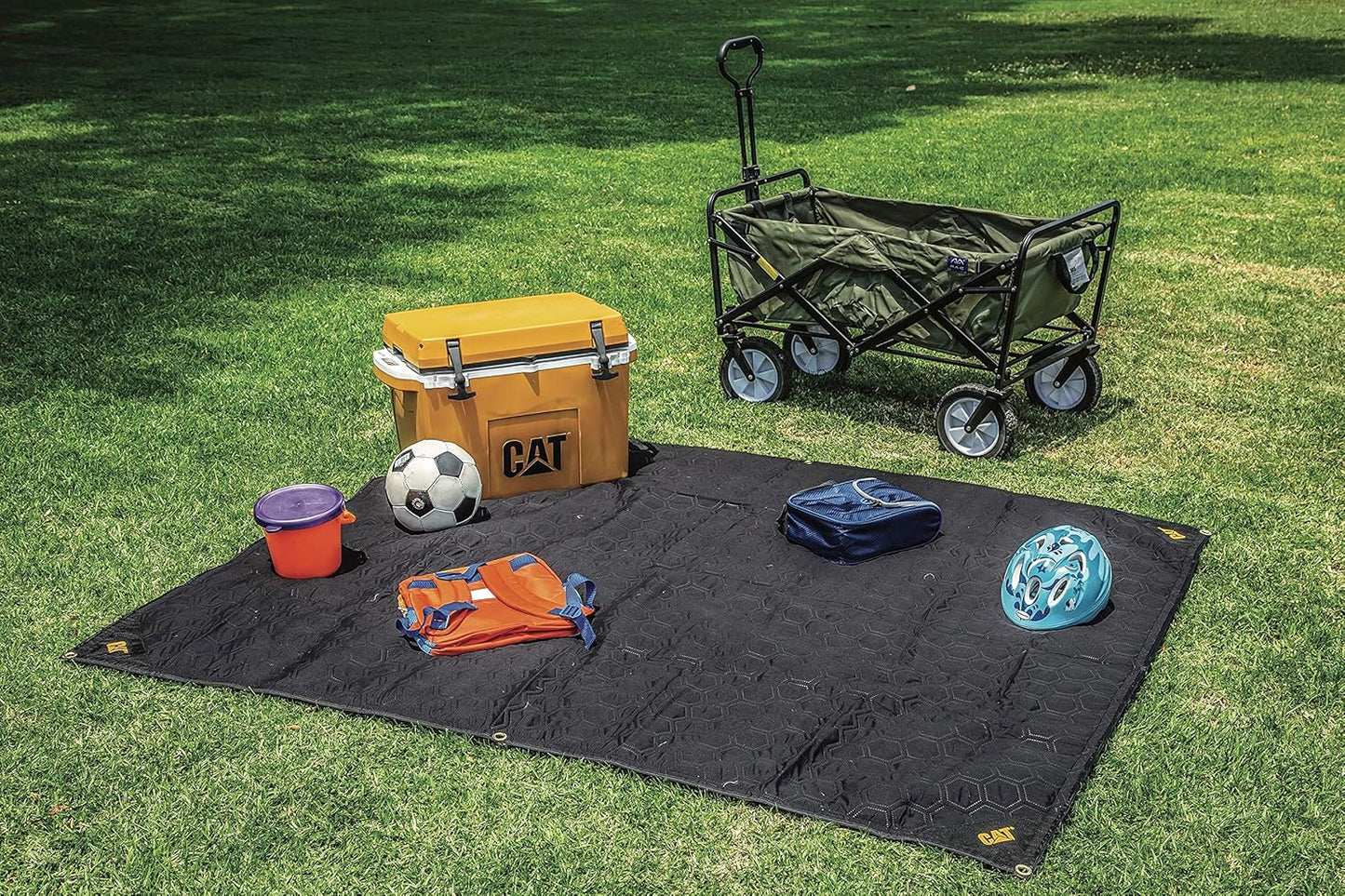CAT premium utility blanket being used as an outdoor picnic mat on the grass.