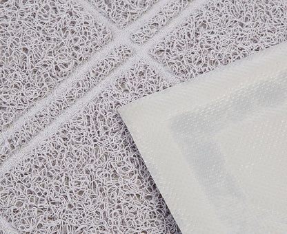 Close-up of the diamond-patterned grooves on the grey PVC litter mat.