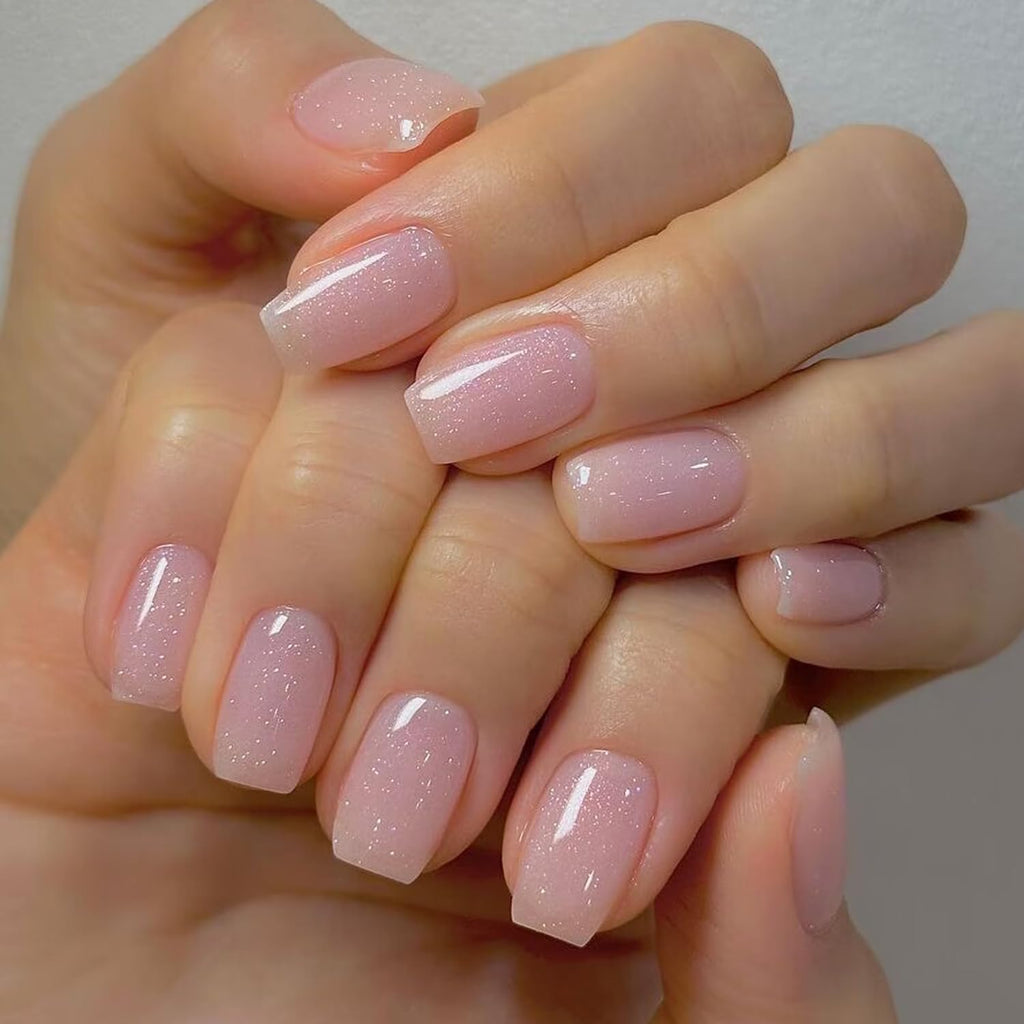 Close-up view of translucent sheer glitter pink gel nail polish swatch on artificial nail.