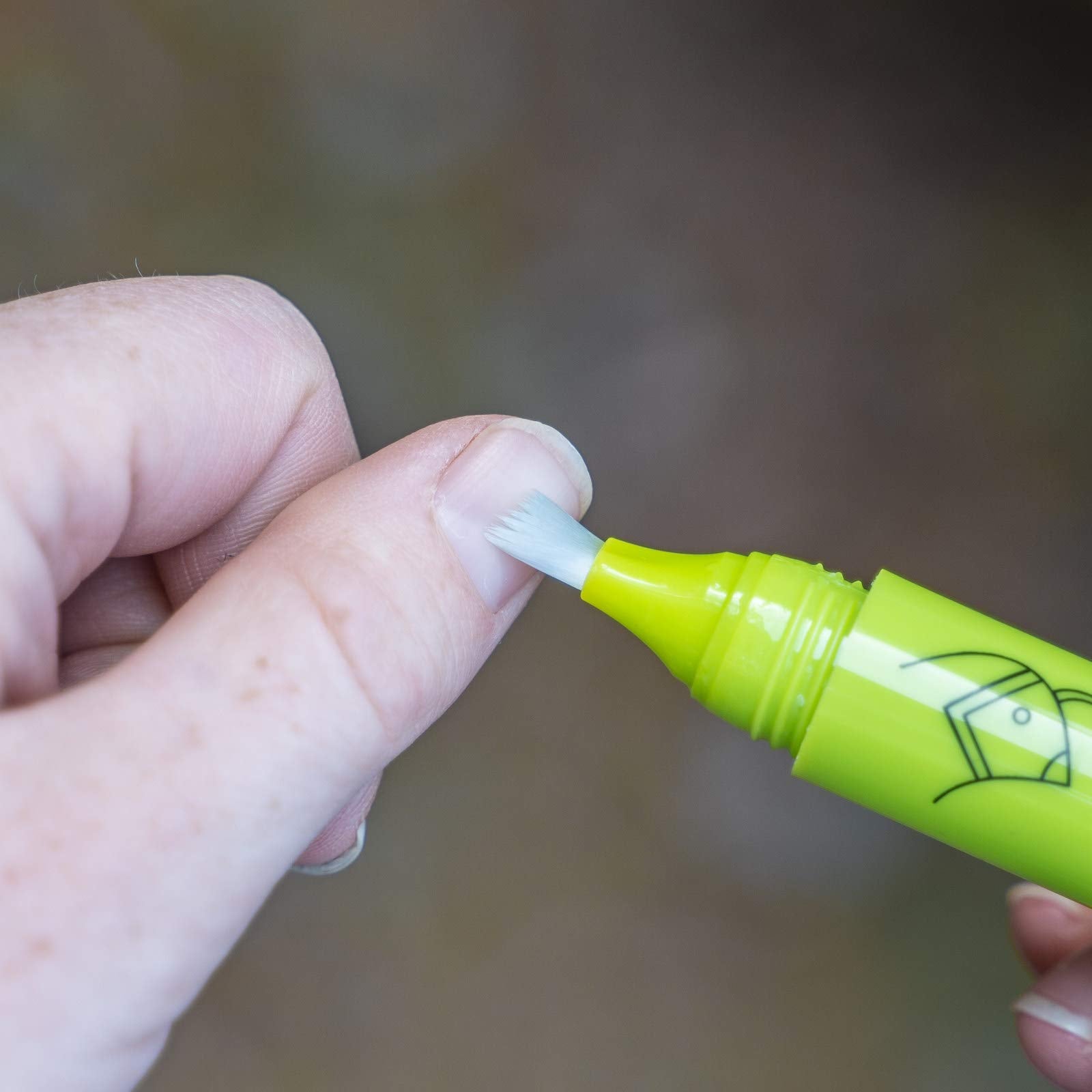 Person applying Nail Quail bitter solution on fingernails