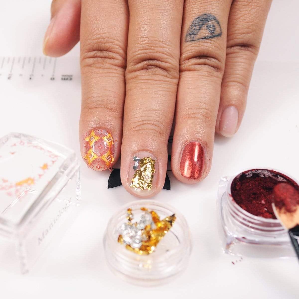 Clear adhering base coat liquid by Maniology inside the glass bottle displaying the brand label for nail stamping enthusiasts