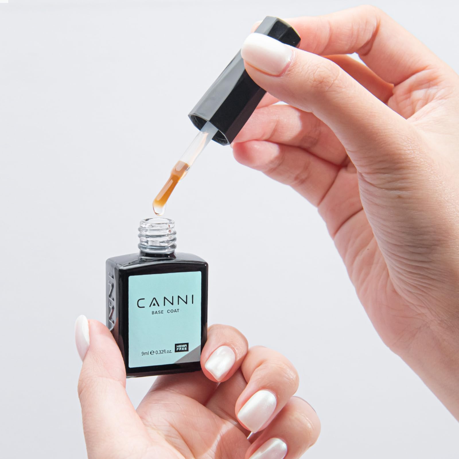 CANNI UV LED soak-off foundational bottle placed next to a modern nail lamp
