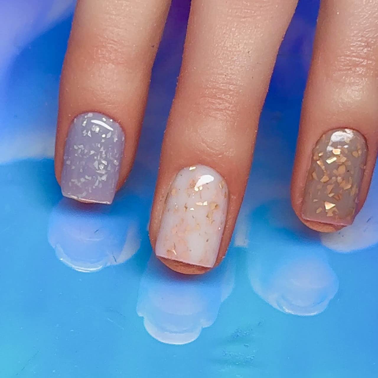 Chic chip resistant professional Russian manicure featuring milky white and gold glitter flakes finish.