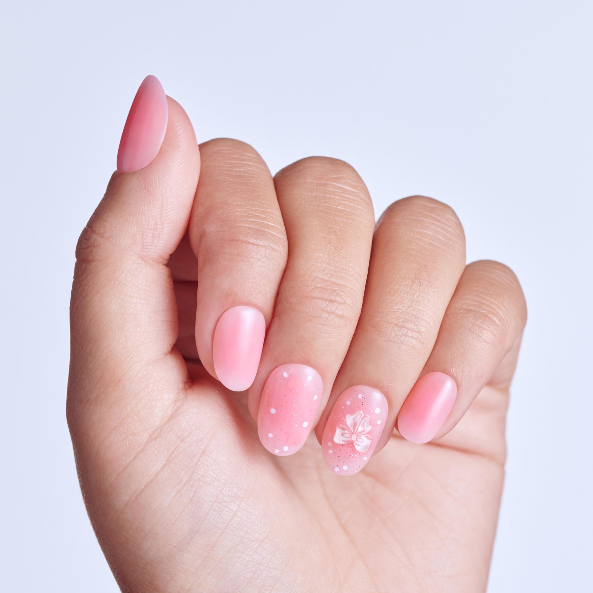 Close up of pink Cupid Love press on nails with 3D bow