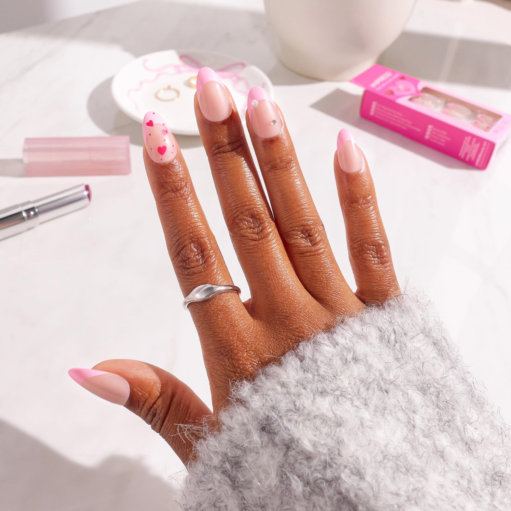 Close up of pink Still The One press on nails with heart details