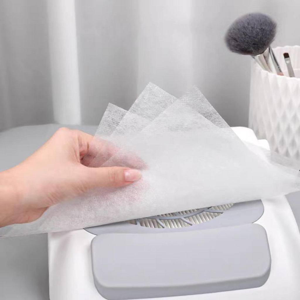 Stack of white disposable nail dust filter sheets