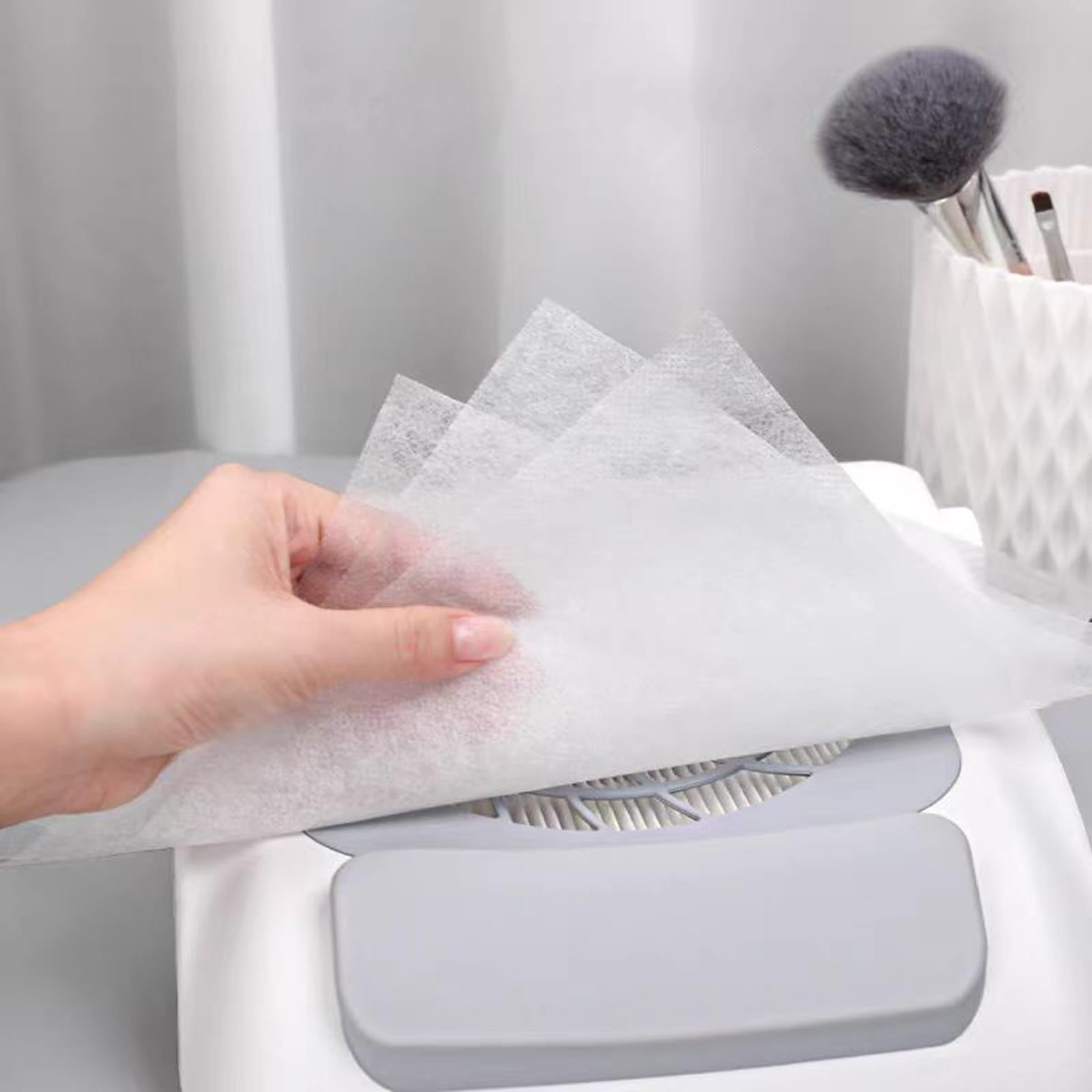 Stack of white disposable nail dust filter sheets