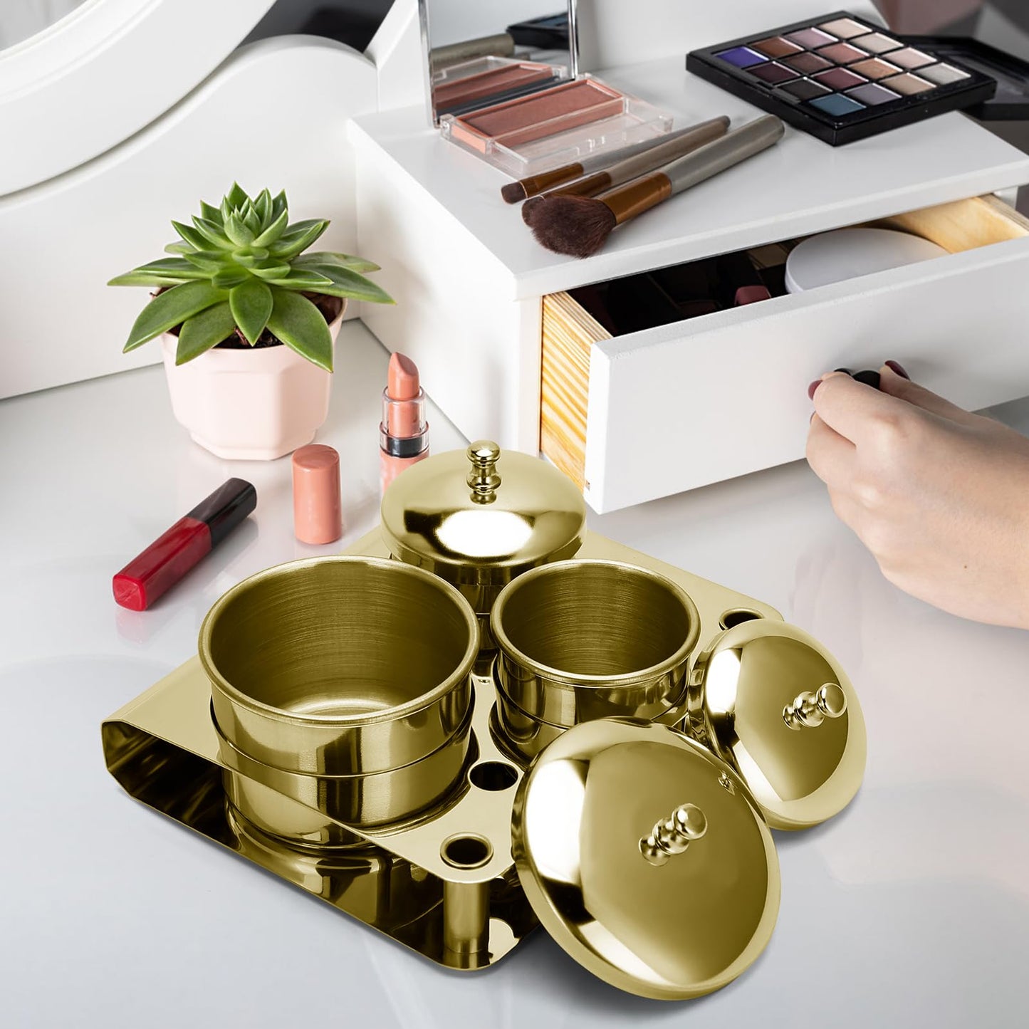 A nail technician using the gold stainless steel monomer cup during a professional acrylic powder application process