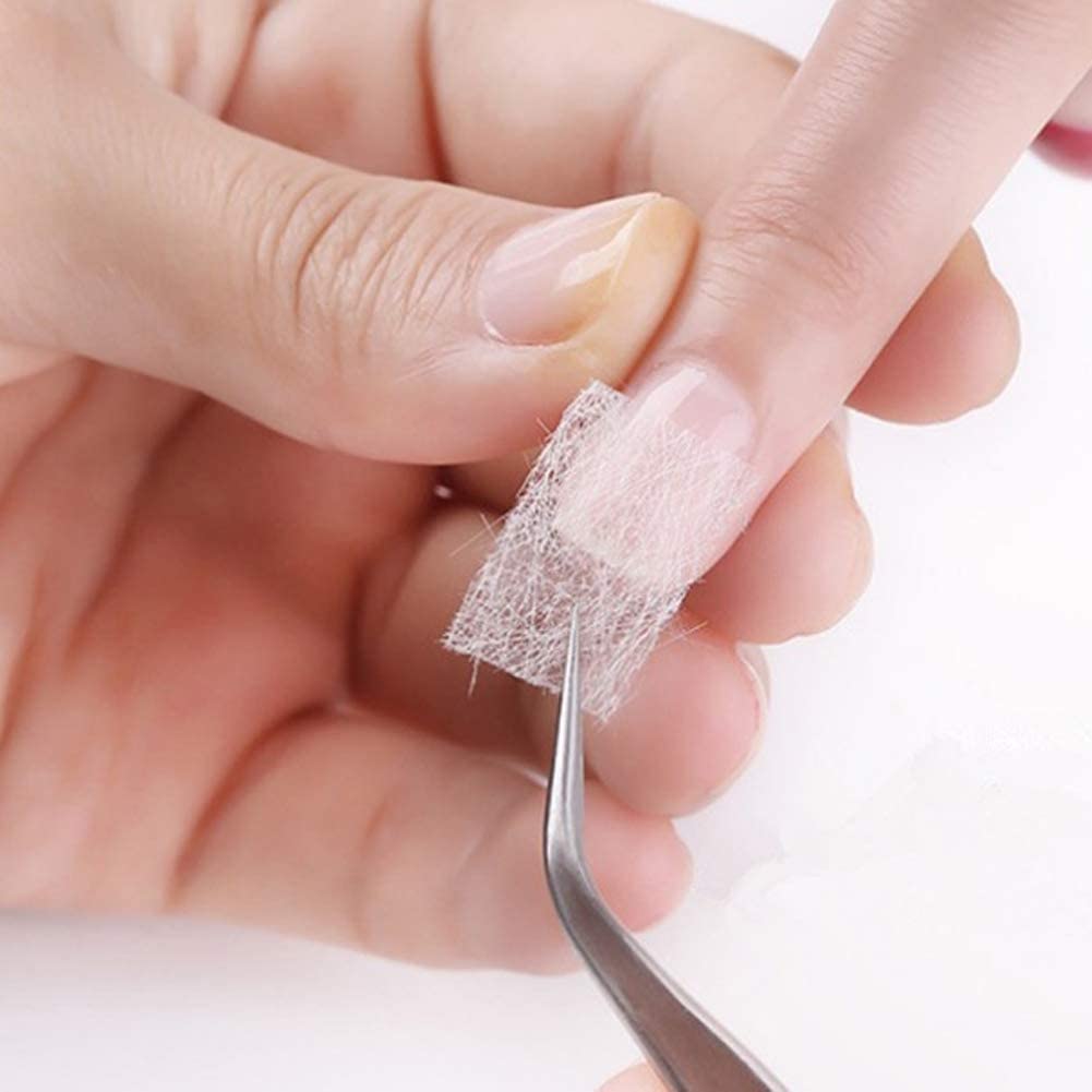 Close up view of non woven fiberglass sheets being trimmed to fit nail width.