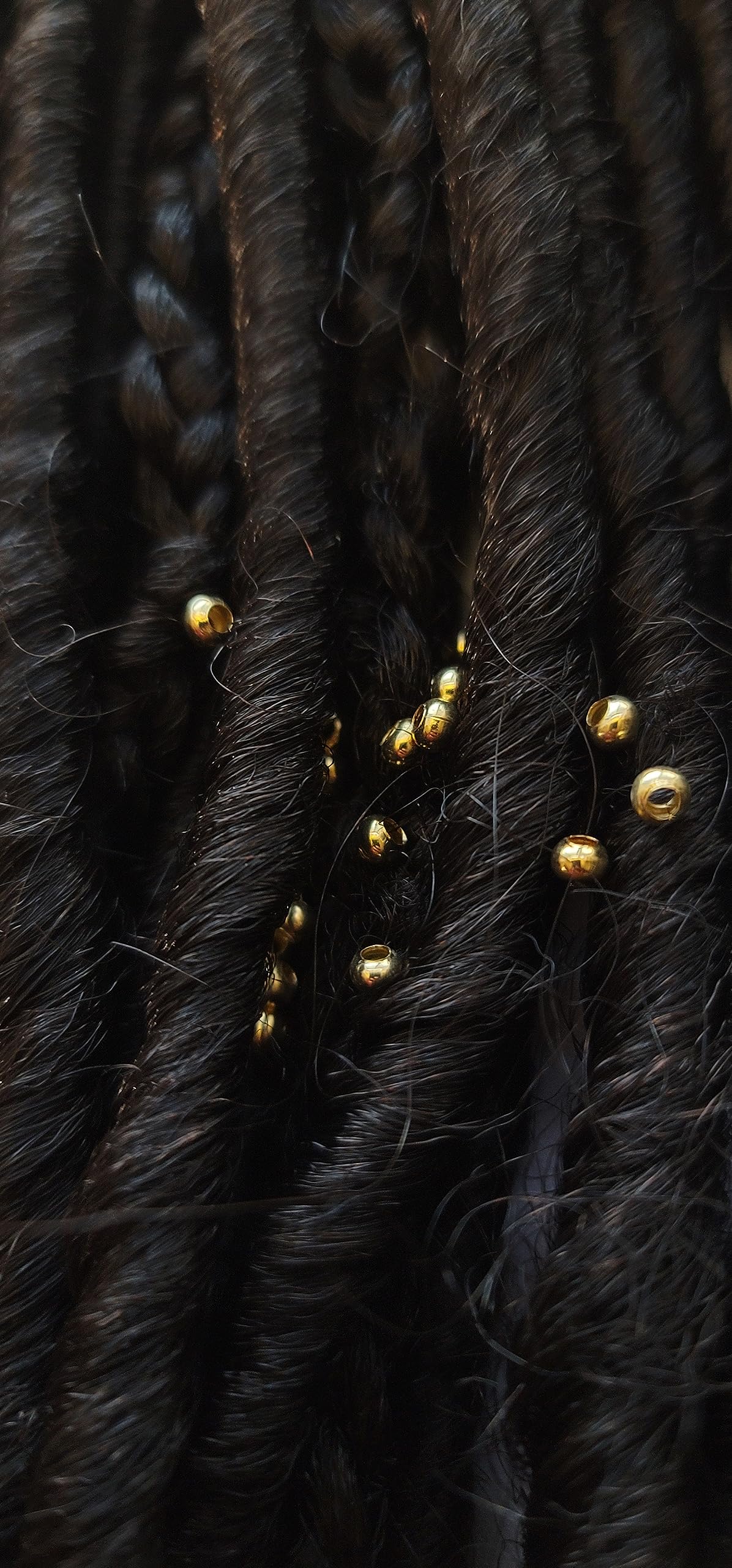 Close up view of sterling silver plated brass 3mm micro hair jewelry pieces on a plain background
