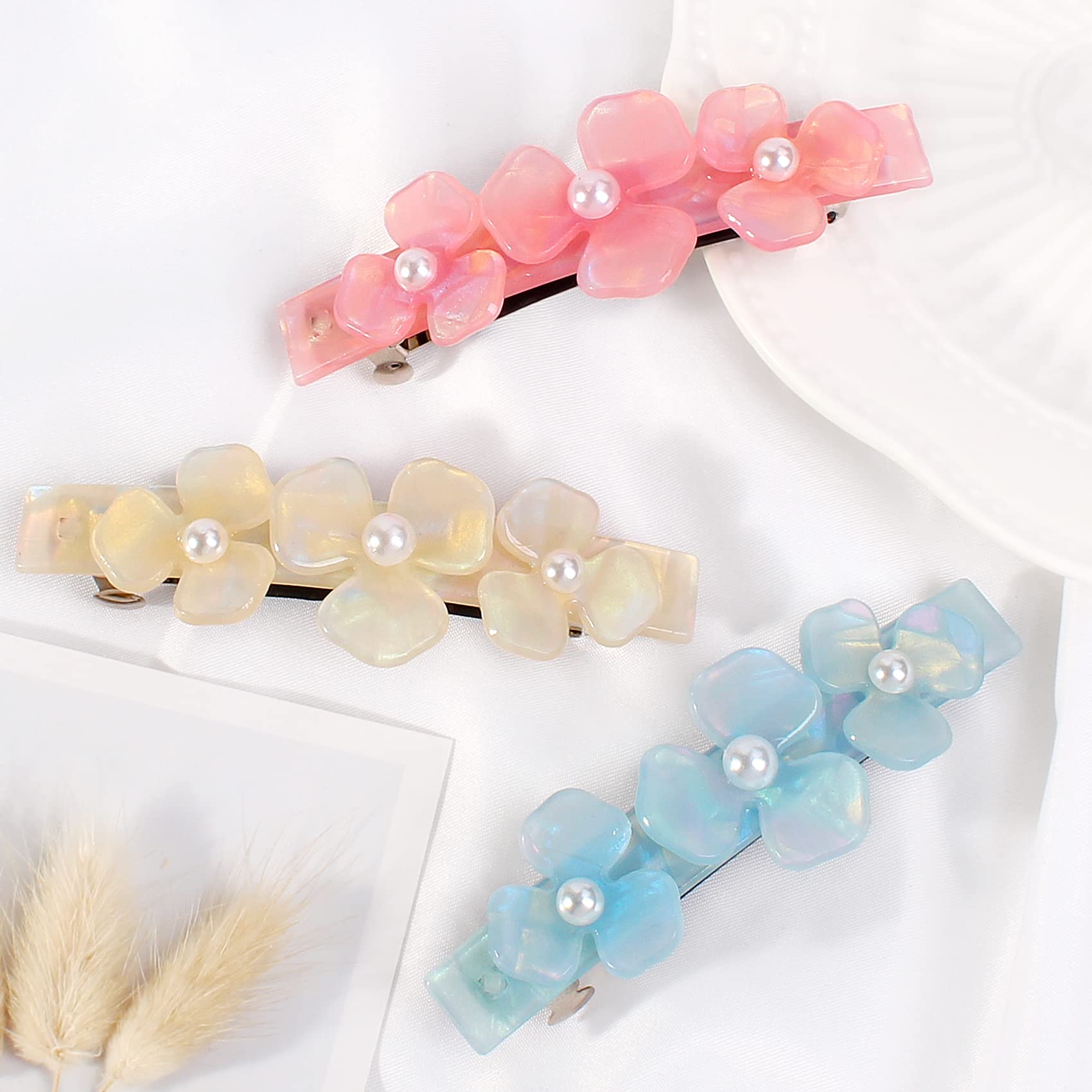 Three pieces of rectangular snap hair clips for thick hair displayed on a flat surface