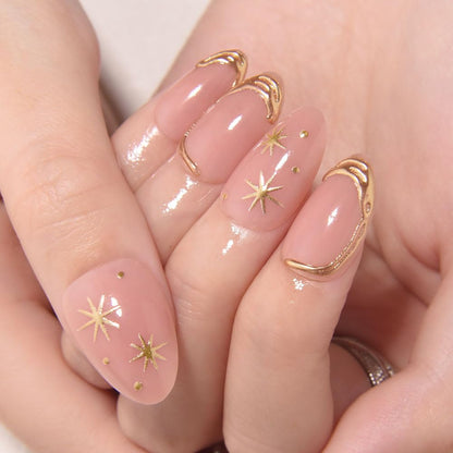 Close up of 3D gold line star detailing on nude glossy press on nails