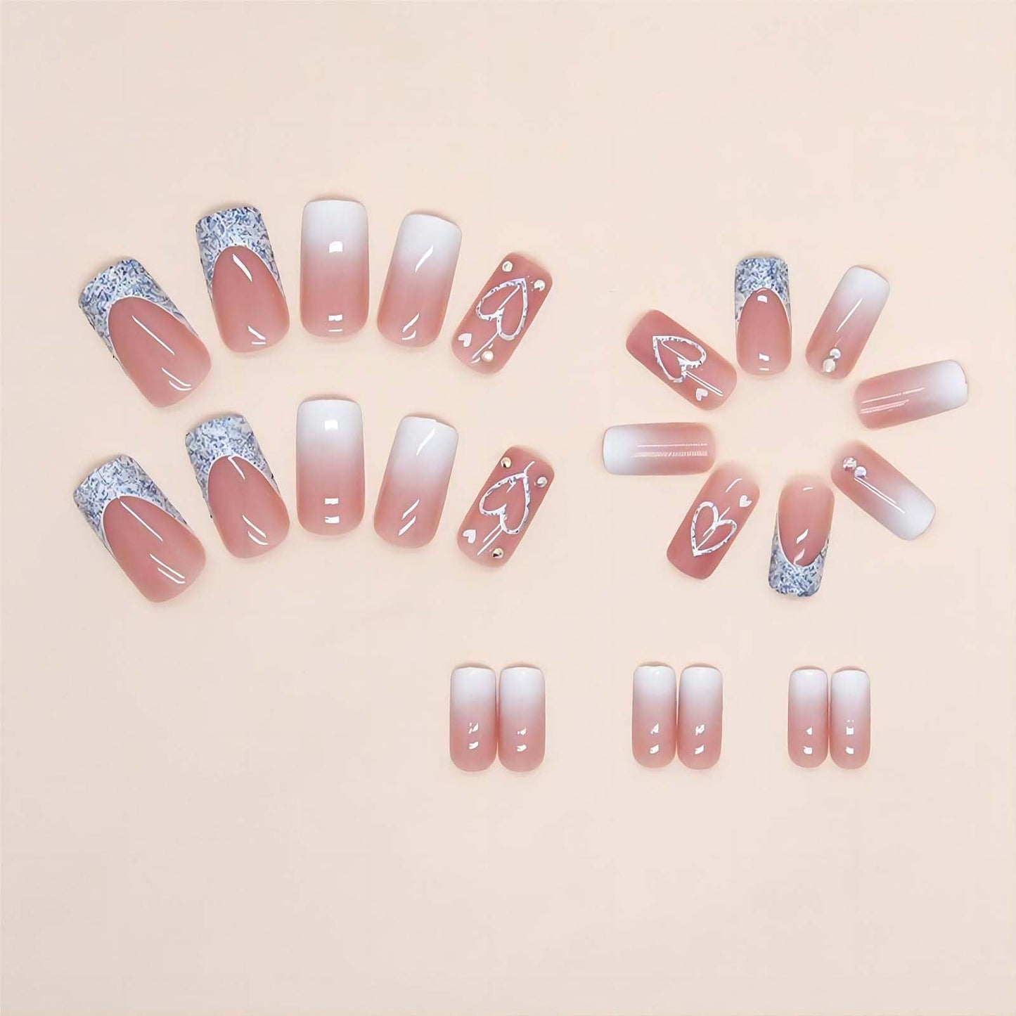 Close up of pink ombre square press on nails with heart detail