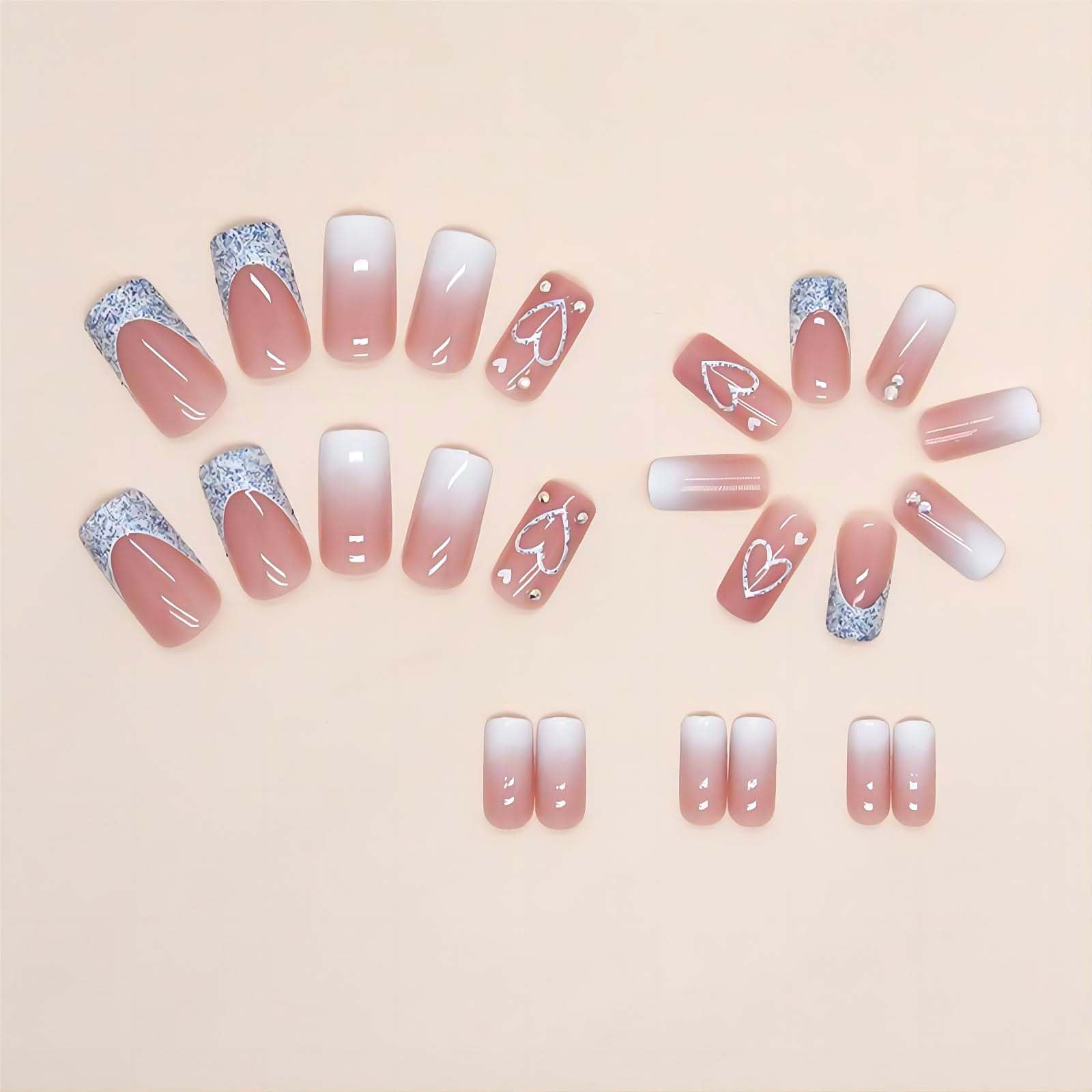 Close up of pink ombre square press on nails with heart detail