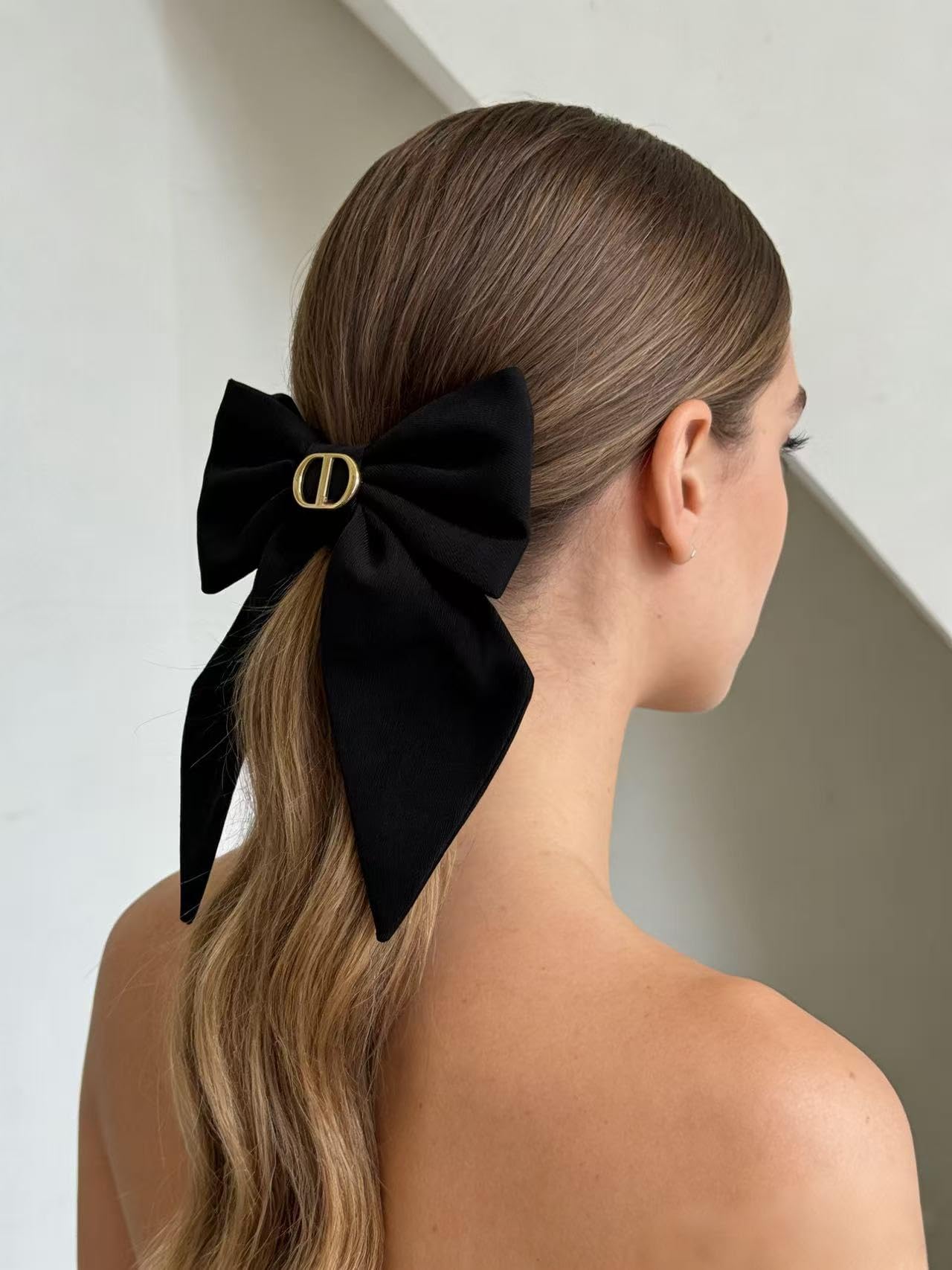 Side profile of the premium structured twist bow accessory worn in a low ponytail