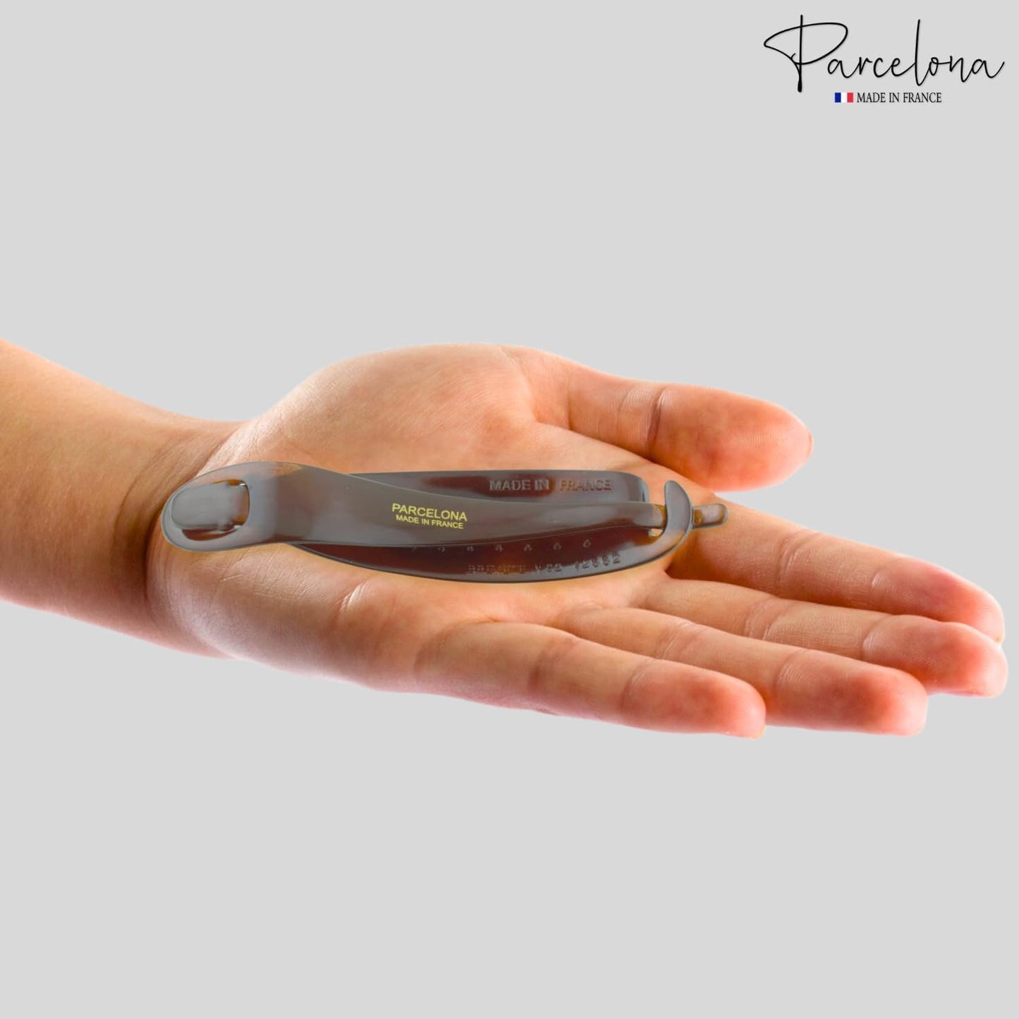 Detailed close up of the elegant brown and black tortoiseshell patterning on the celluloid hair clip.