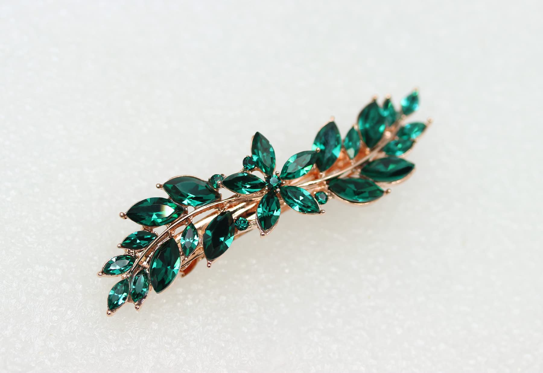 Faship premium imported bridal hair jewelry piece highlighting the detailed craftsmanship of the emerald green rhinestones and alloy metal base.