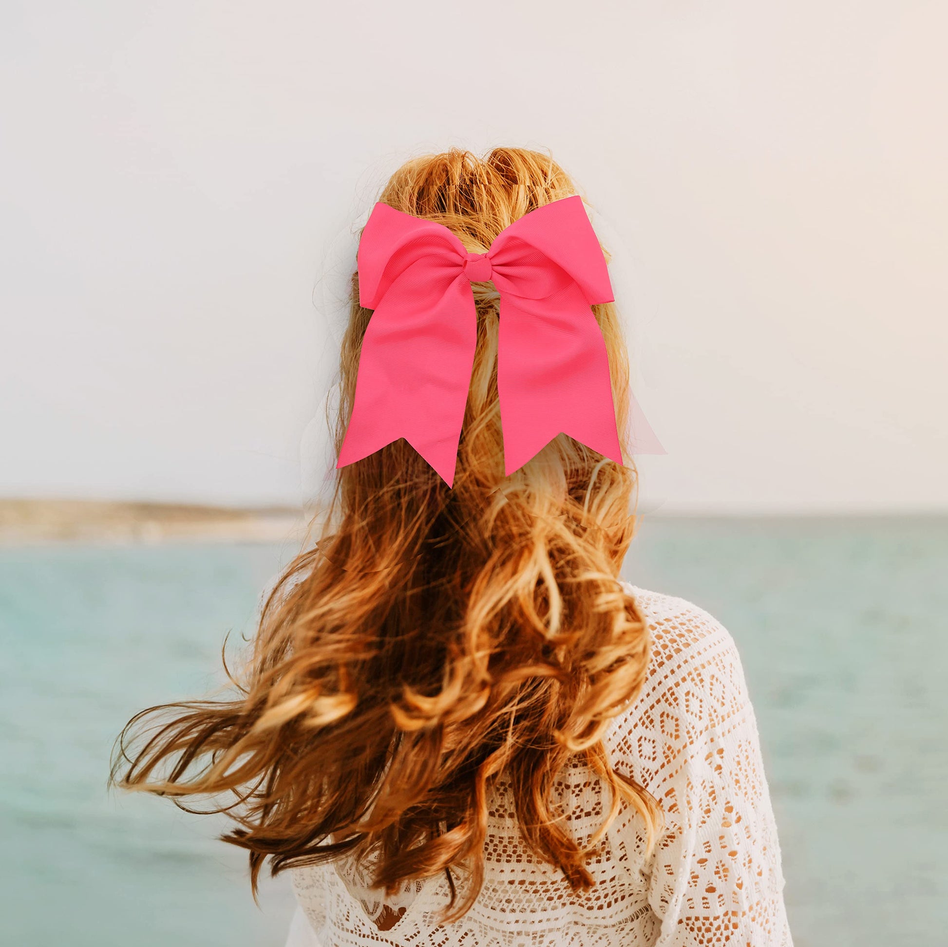 Oversized neon pink hair bow with long tails by Motique Accessories showcasing the three inch metal alligator clip.