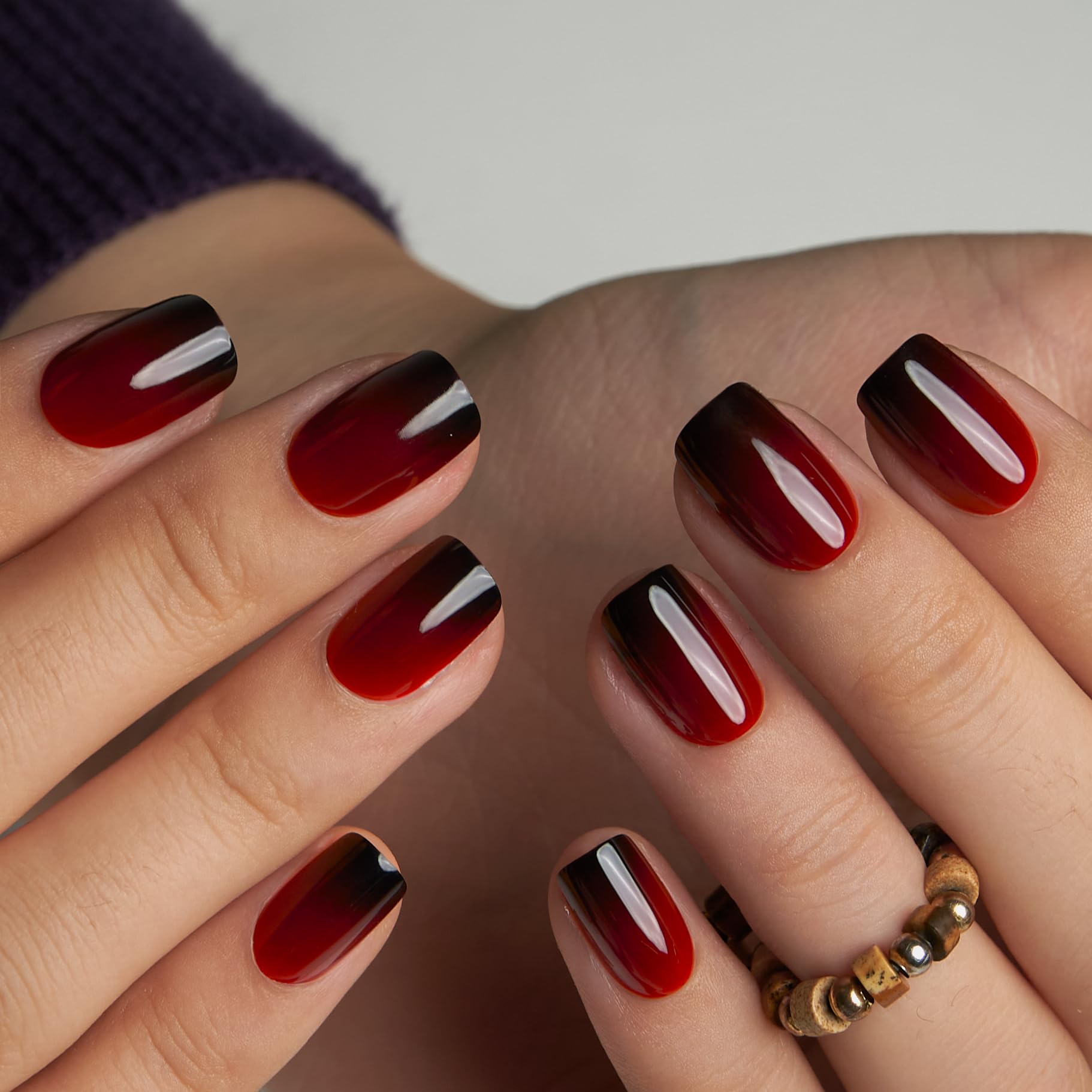 Close up of glossy red ombre nail tip finish