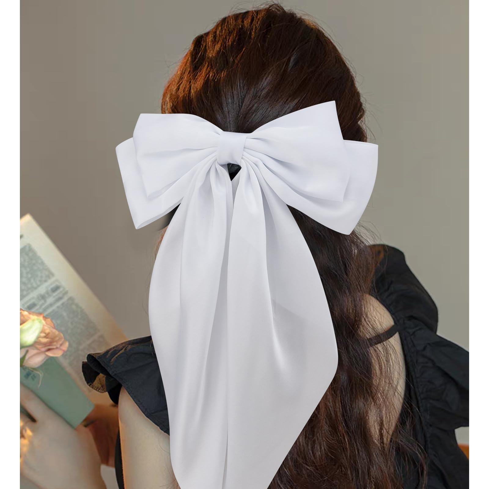 Oversized pink satin ribbon hair clip showcasing the long tail design and smooth fabric texture