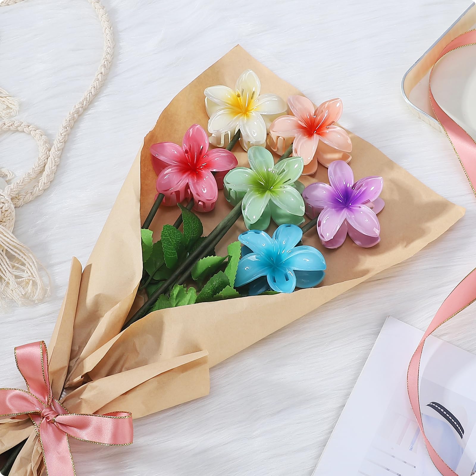 Six pieces of multicolored gradient plumeria hair accessories displayed together